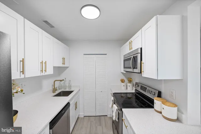 a kitchen with a sink a stove and cabinets