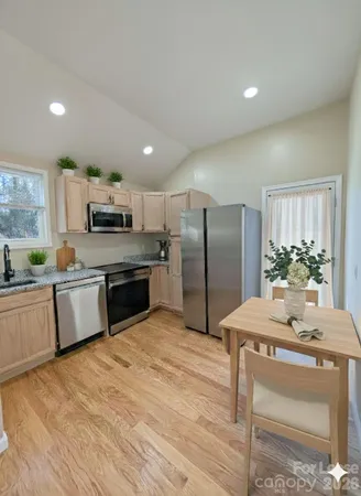 a kitchen with granite countertop a refrigerator and a stove top oven