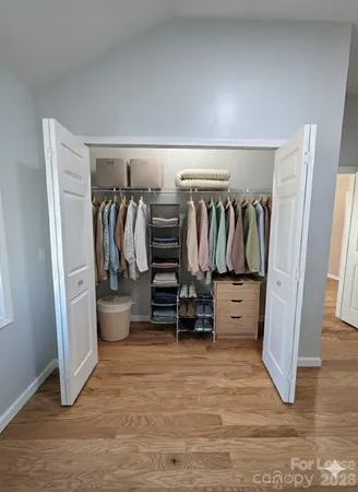 a view of walk in closet with clothes and shoes