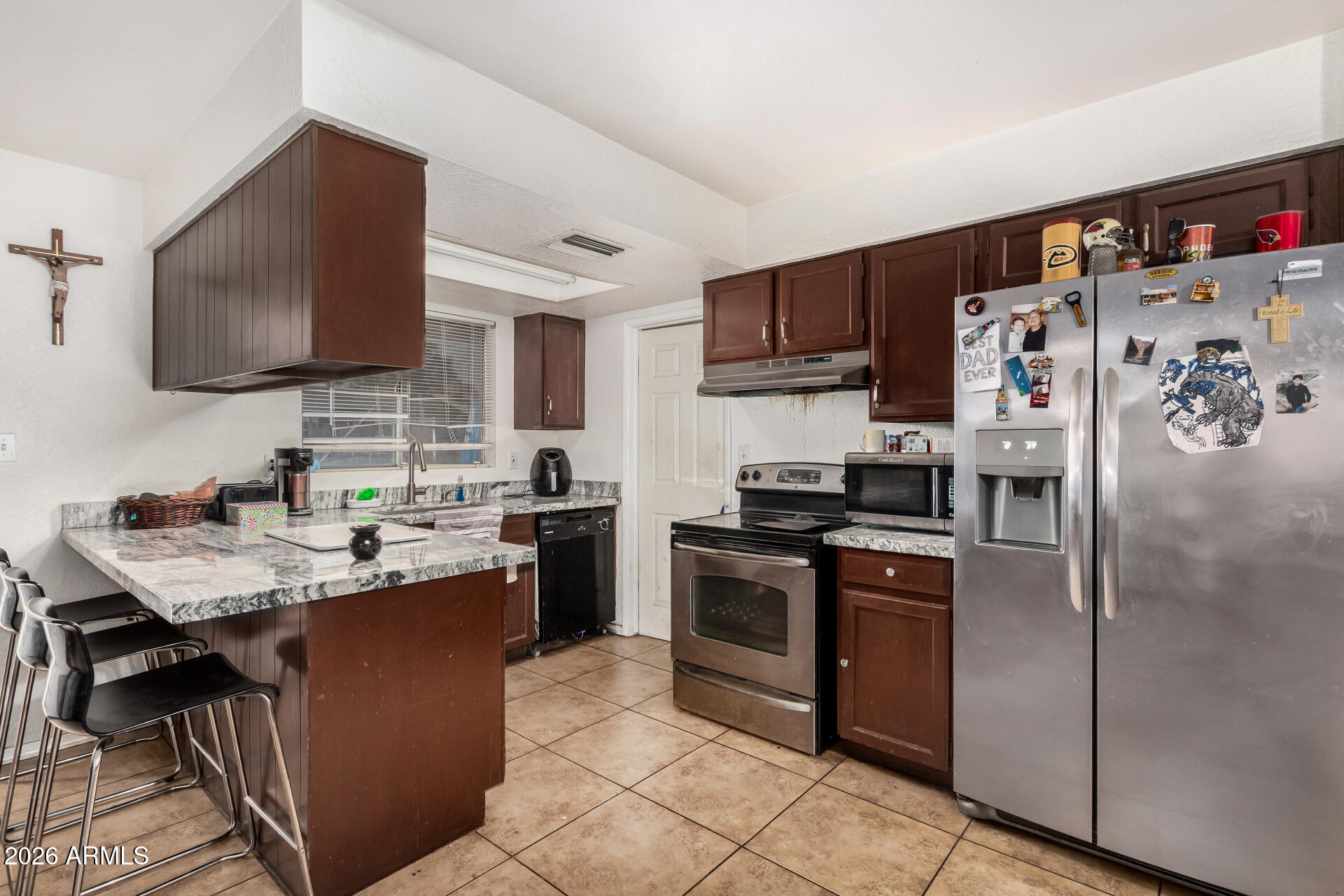 7522 West Cheery Lynn Road Phoenix, AZ 85033 - Photo 3 of 14 a kitchen with stainless steel appliances granite countertop a sink stove and refrigerator