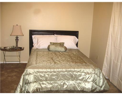 7122 Premont Drive, Unit C104 Corpus Christi, TX 78414 - Photo 5 of 9 a bedroom with a bed and wooden floor