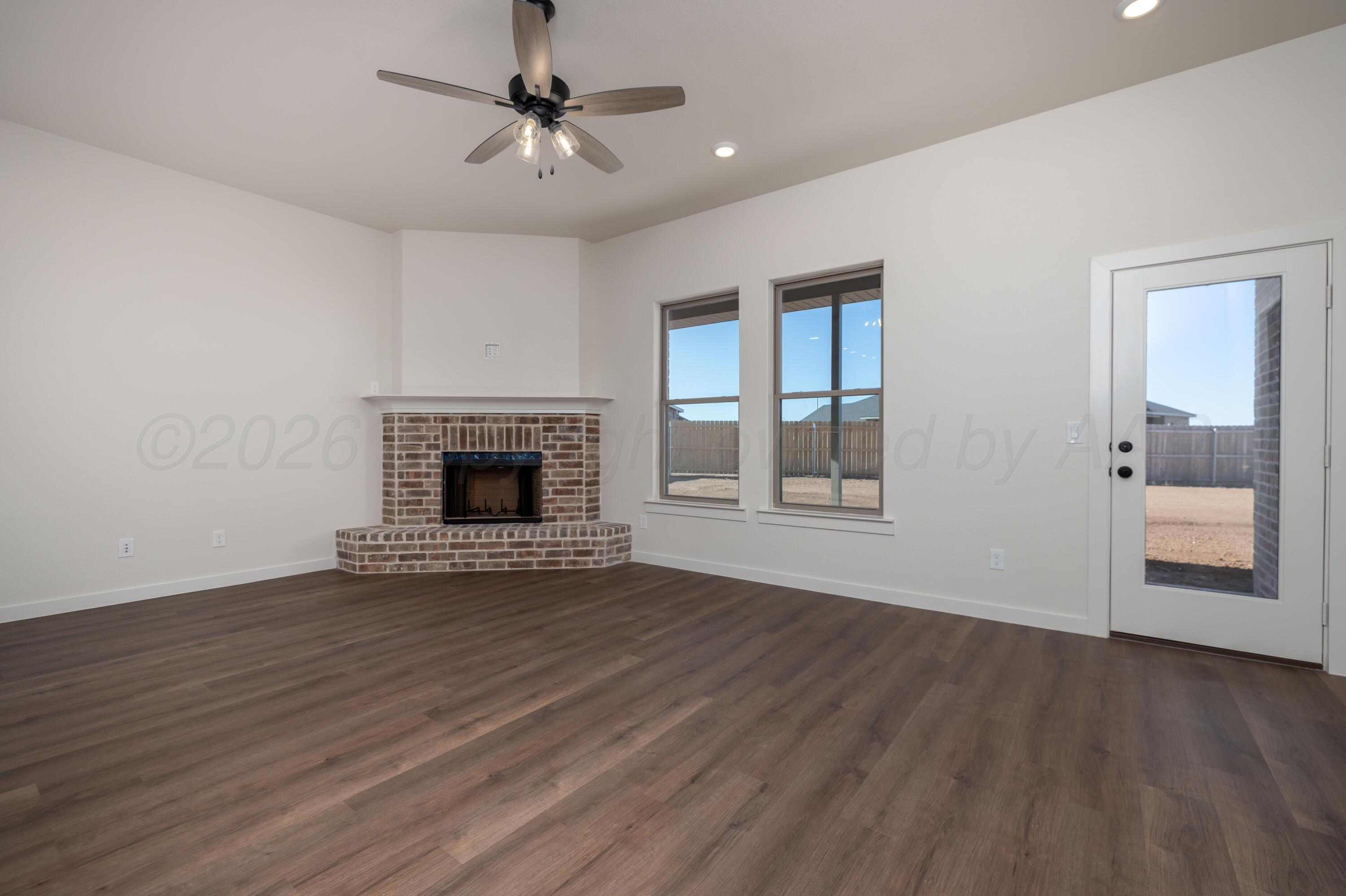 3000 Flycatcher Road Amarillo, TX 79124 - Photo 2 of 11 a view of an empty room with wooden floor fireplace and a window