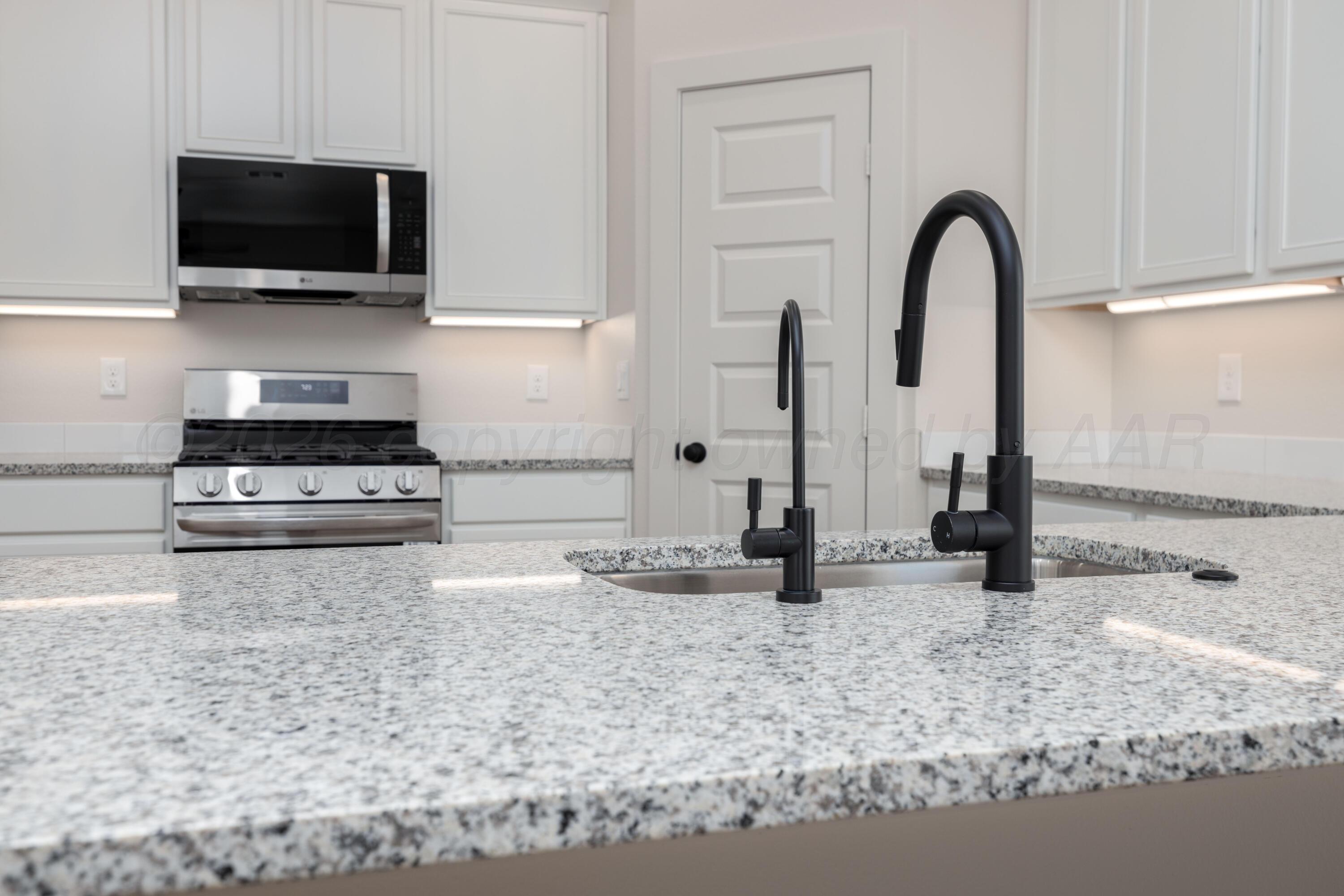 3000 Flycatcher Road Amarillo, TX 79124 - Photo 4 of 11 a kitchen with stainless steel appliances granite countertop a sink a stove and a microwave