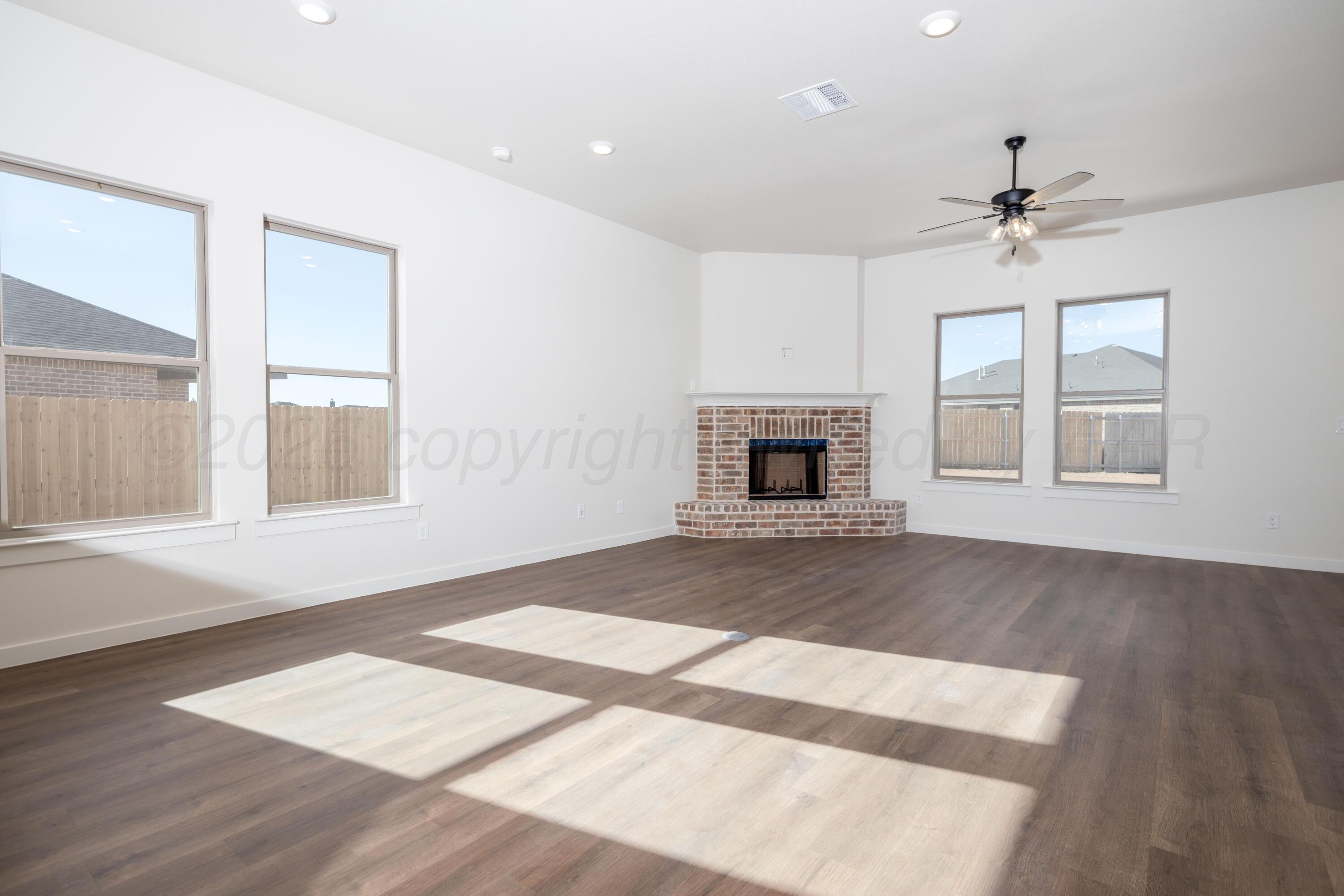 3000 Flycatcher Road Amarillo, TX 79124 - Photo 5 of 11 a view of an empty room with wooden floor fireplace and a window