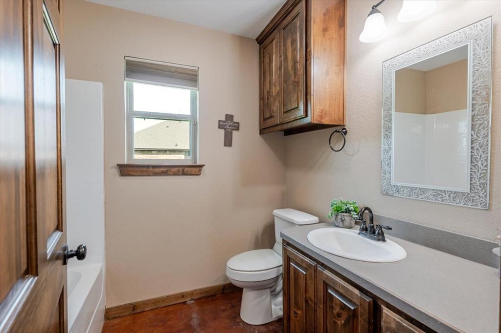 181 Savannah Drive Weatherford, TX 76087 - Photo 15 of 36 a bathroom with a sink a toilet and mirror