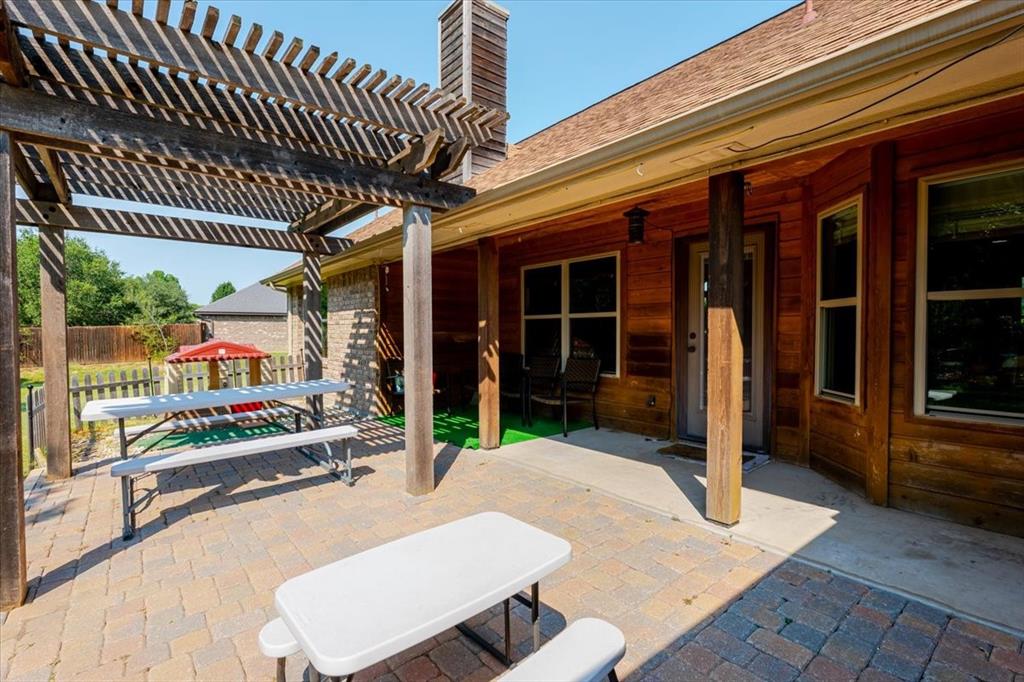 181 Savannah Drive Weatherford, TX 76087 - Photo 26 of 36 a view of a patio with table and chairs with wooden floor and fence