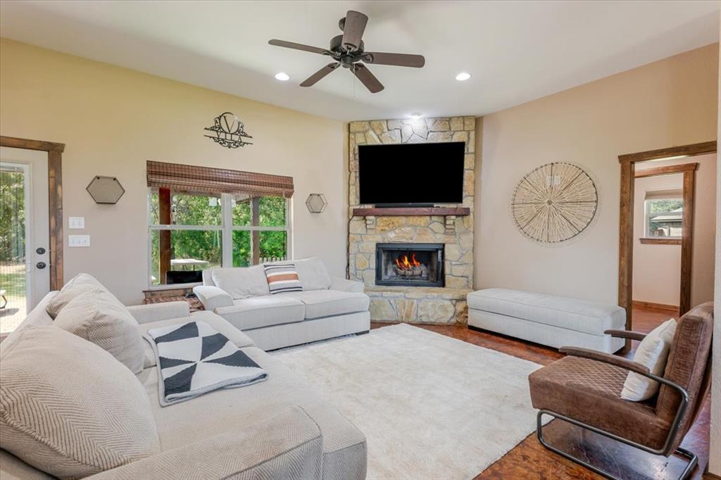 181 Savannah Drive Weatherford, TX 76087 - Photo 5 of 36 a living room with furniture a fireplace and a flat screen tv