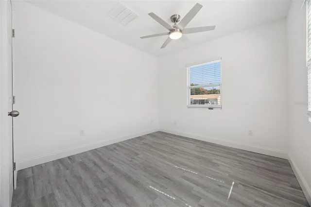 an empty room with wooden floor and window