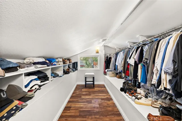 a view of walk in closet with clothes and shoes