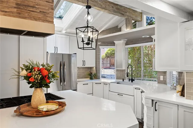 a kitchen with stainless steel appliances kitchen island granite countertop a sink cabinets and a large window