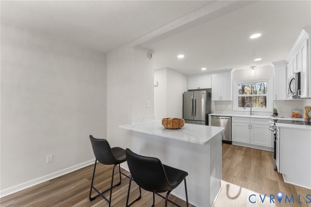 10209 Stonemill Road Henrico, VA 23233 - Photo 14 of 28 a kitchen with stainless steel appliances a table and chairs in it