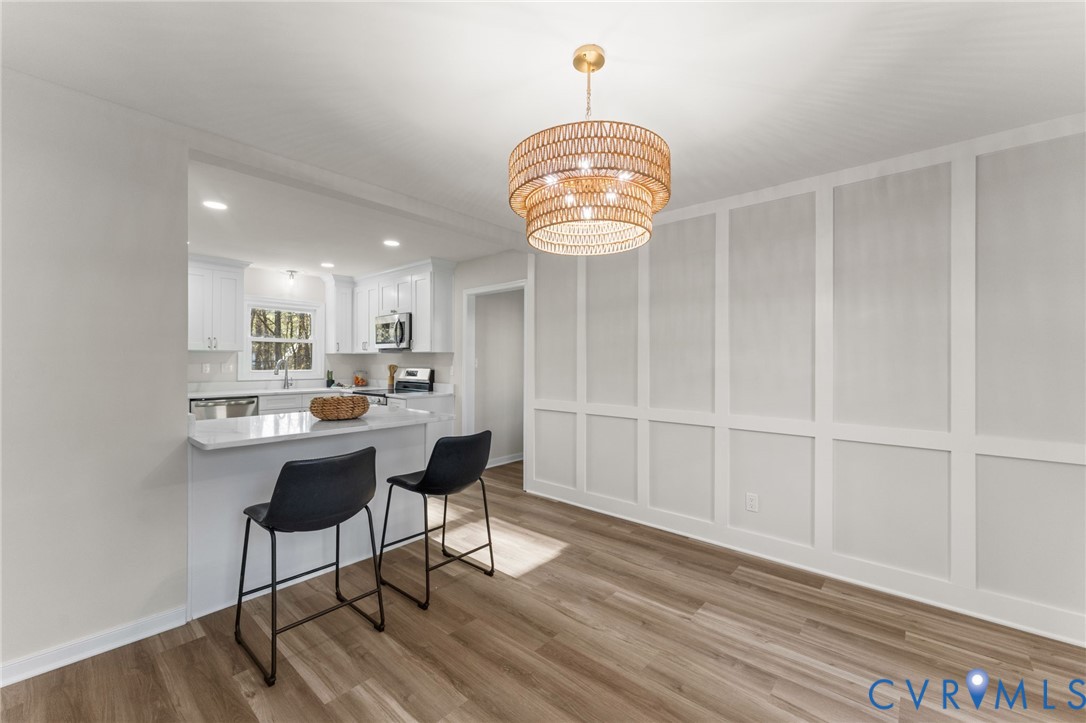 10209 Stonemill Road Henrico, VA 23233 - Photo 16 of 28 a view of a dining room with furniture wooden floor and chandelier
