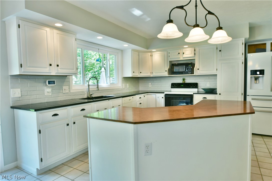 13491 Woodin Road Chardon, OH 44024 - Photo 20 of 35 Kitchen with decorative light fixtures, sink, white appliances, and white cabinets