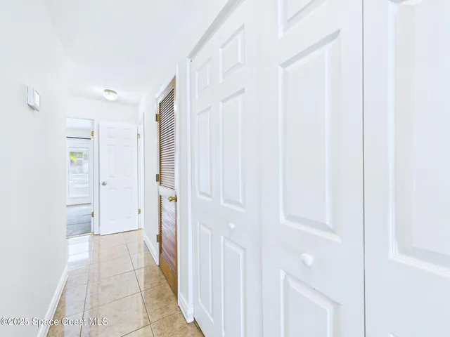 a view of a hallway with wooden floor and entryway