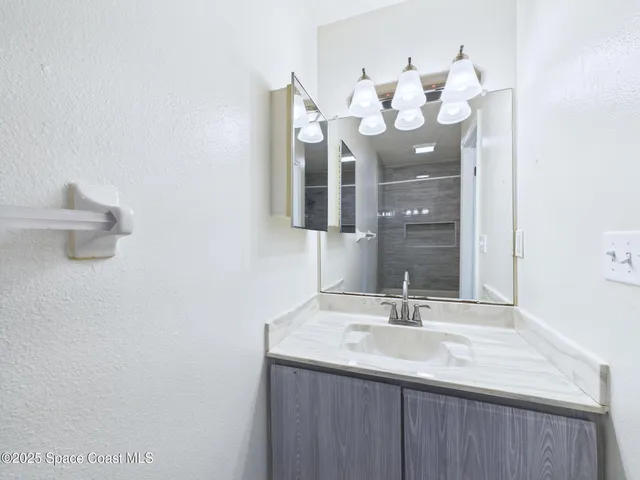 a bathroom with a sink vanity and a mirror