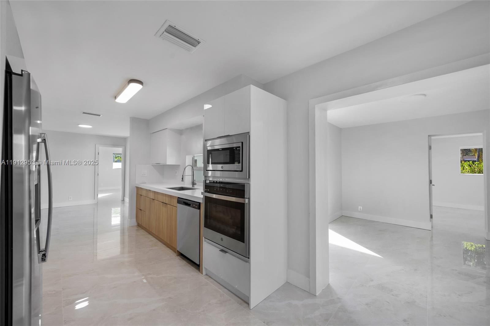 4500 Monroe Street Hollywood, FL 33021 - Photo 18 of 67 a kitchen with stainless steel appliances kitchen island granite countertop a refrigerator and a sink