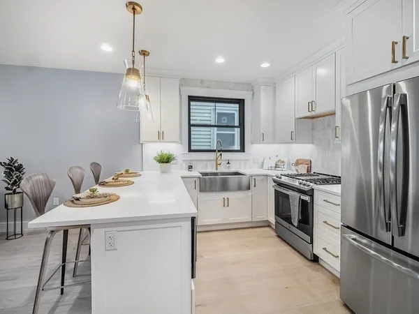 a kitchen with a sink stainless steel appliances and window