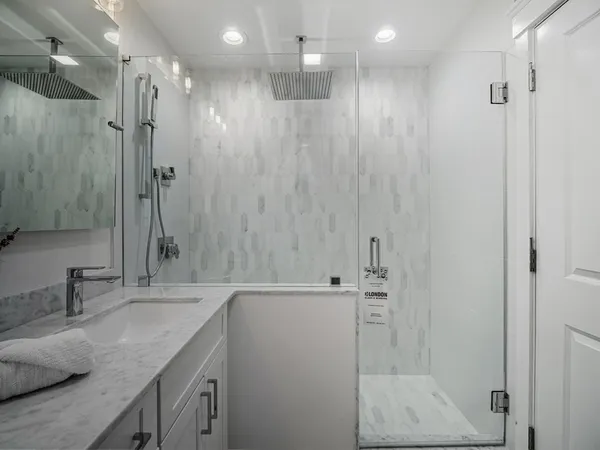 a bathroom with a granite countertop sink a shower and a mirror