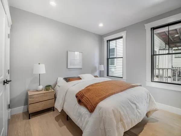 a bedroom with a bed and wooden floor