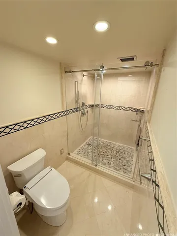 a bathroom with a toilet and a shower