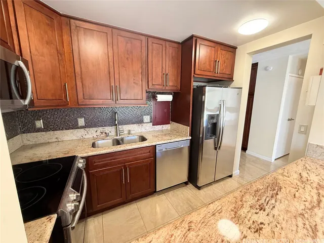 a kitchen with stainless steel appliances granite countertop a refrigerator sink and cabinets
