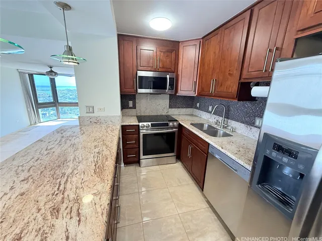 a large kitchen with stainless steel appliances granite countertop a stove sink and cabinets