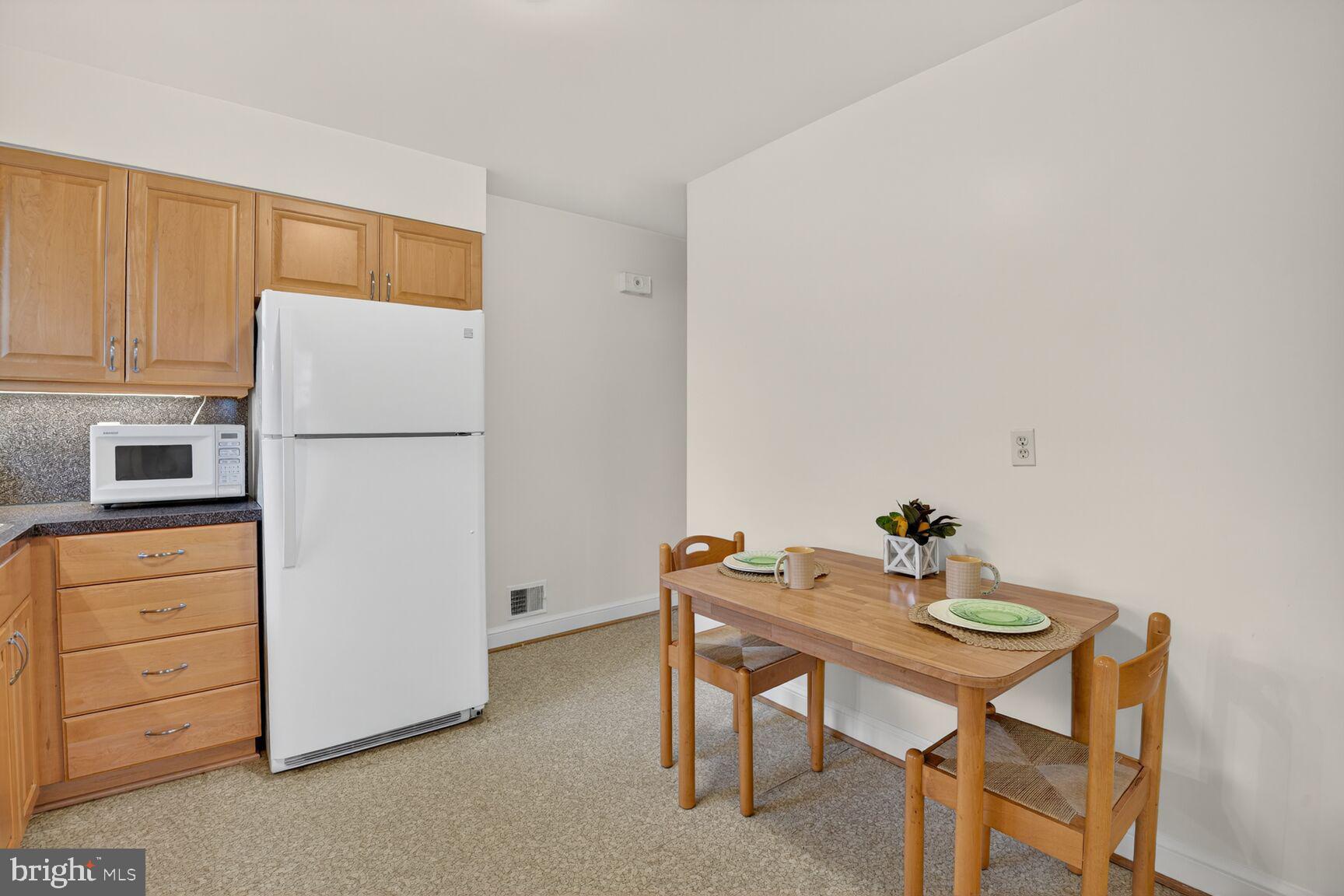 10704 Jamaica Drive Silver Spring, MD 20902 - Photo 9 of 26 a white kitchen with a table and chairs