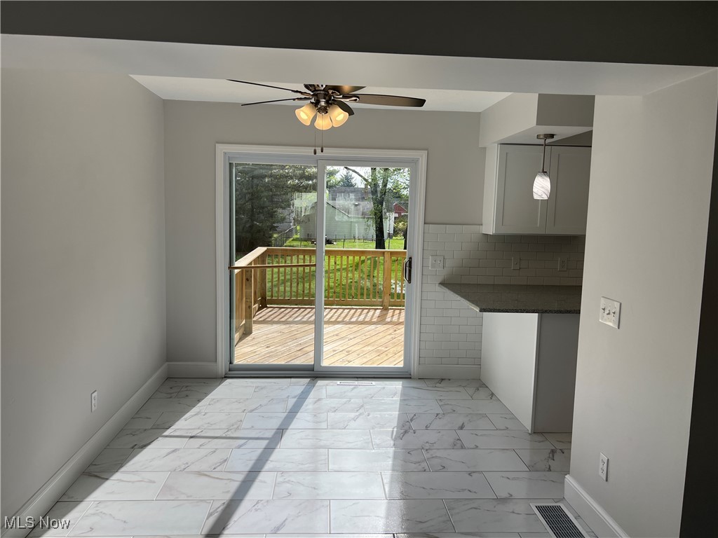 1279 Lander Road Cleveland, OH 44124 - Photo 15 of 37 Unfurnished dining area featuring baseboards, marble finish floor, and a ceiling fan