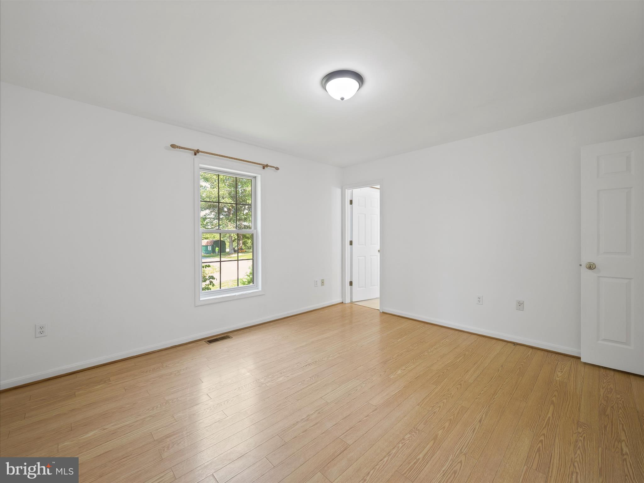 19135 Swinging Bridge Road Boonsboro, MD 21713 - Photo 23 of 38 a view of an empty room with wooden floor and a window