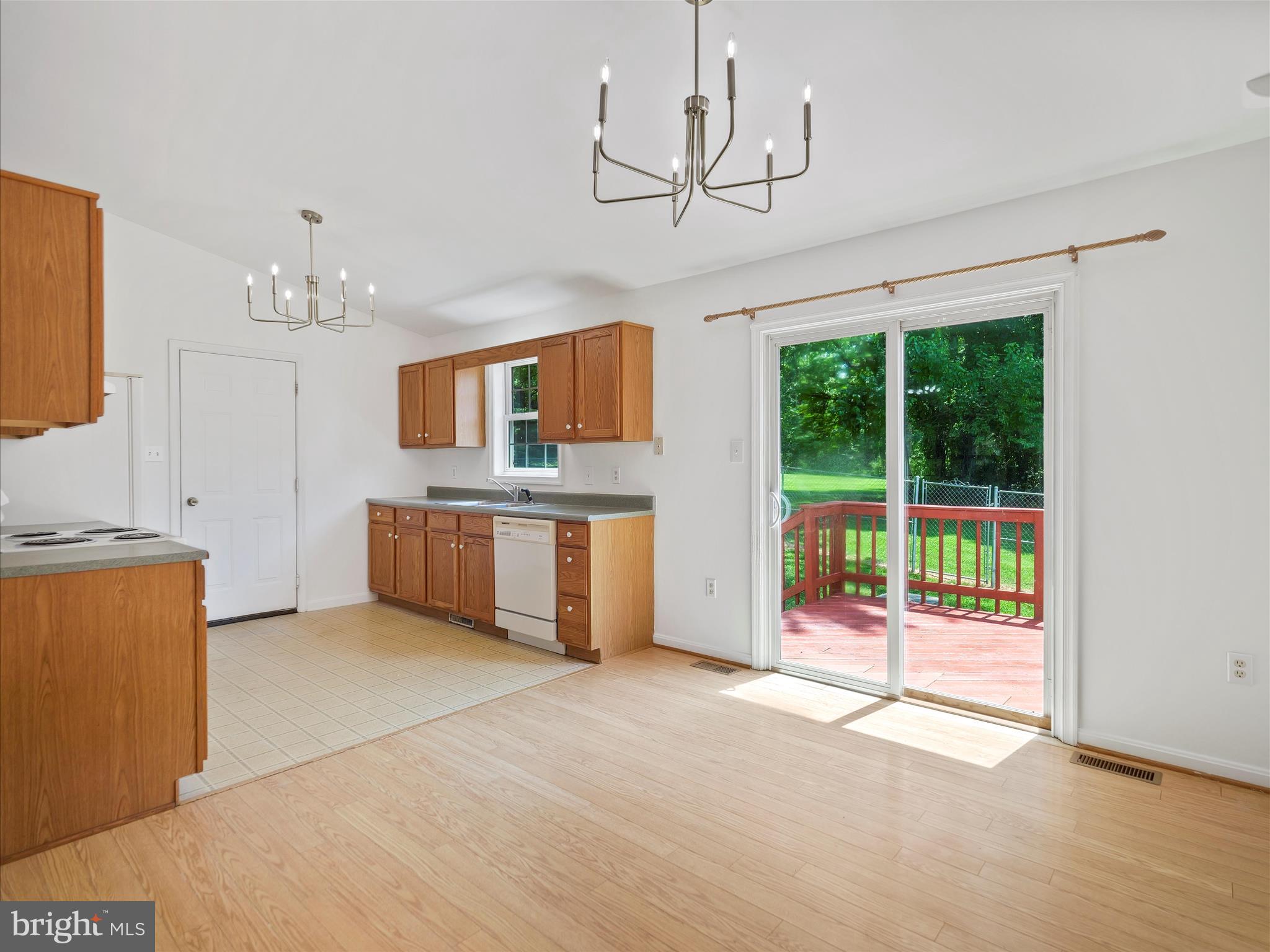 19135 Swinging Bridge Road Boonsboro, MD 21713 - Photo 9 of 38 a view of a kitchen with a dishwasher cabinets a fireplace and a chandelier