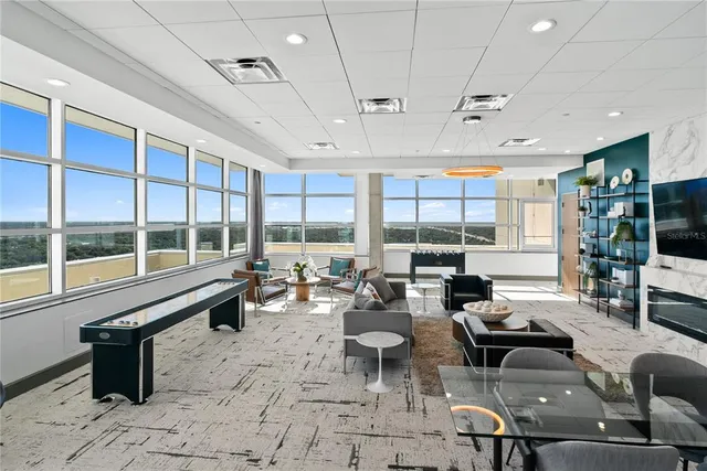 a living room with patio furniture and floor to ceiling windows
