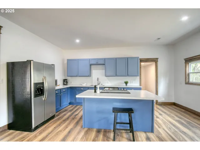 a kitchen with stainless steel appliances granite countertop a sink refrigerator and cabinets