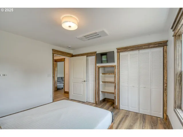 a view of an empty room with closet and a window