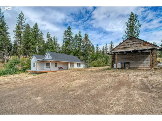 a front view of a house with a garden and trees