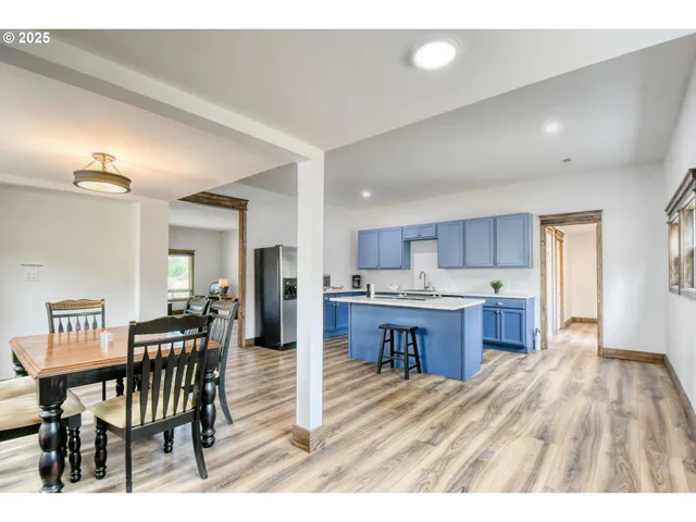 a open kitchen with kitchen island a table and chairs in it