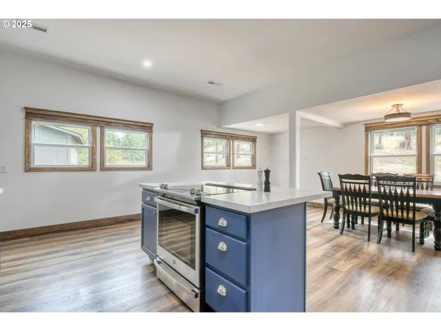 a kitchen with a wooden floor and chairs