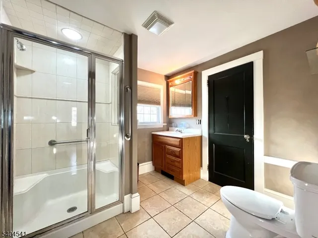 a bathroom with a glass door shower and a sink
