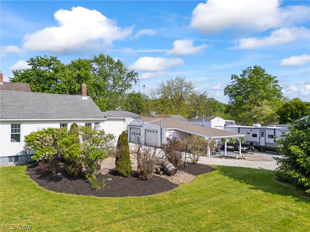 258 Randolph Road Mogadore, OH 44260 - Photo 40 of 49 Expansive green lawn with mature landscaping beds and a stone patio