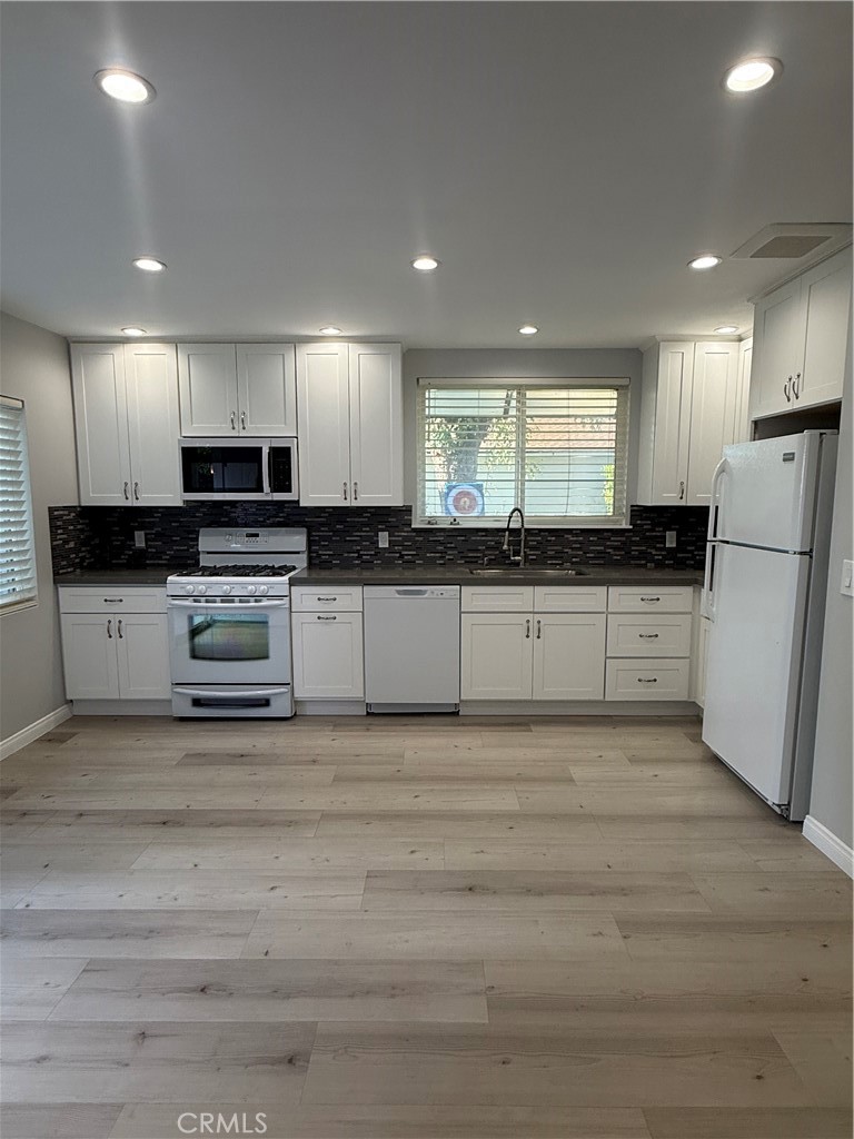 6504 Hesperia Avenue Reseda, CA 91335 - Photo 3 of 11 a kitchen with stainless steel appliances granite countertop a stove a sink and a refrigerator