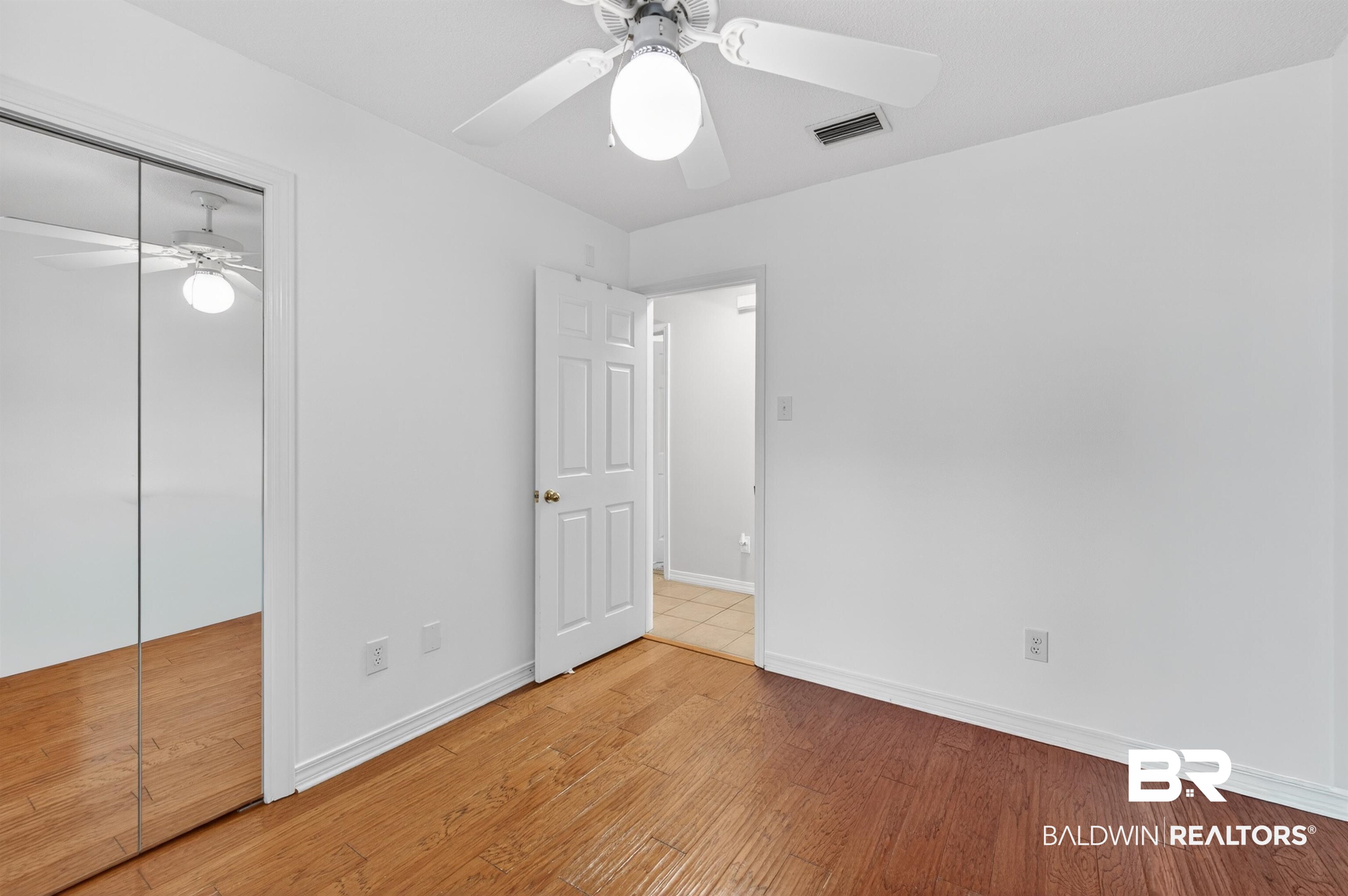 9624 North Bay Street Foley, AL 36535 - Photo 28 of 59 Room featuring wood-finish flooring, a ceiling fan with integrated lighting, and white baseboards
