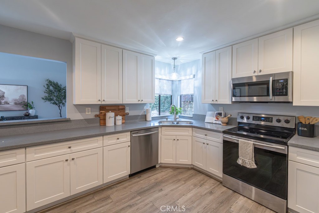 5002 East Atherton Street Long Beach, CA 90815 - Photo 13 of 52 a kitchen with stainless steel appliances granite countertop a sink a stove a microwave and cabinets