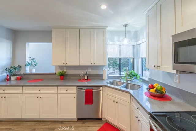 a kitchen with granite countertop white cabinets and white appliances