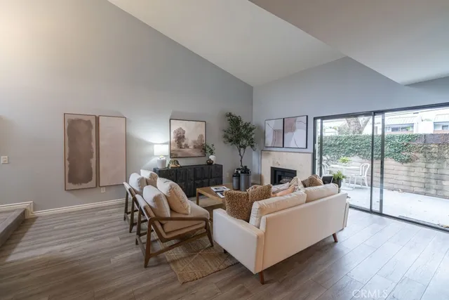 a living room with fireplace furniture and a large window