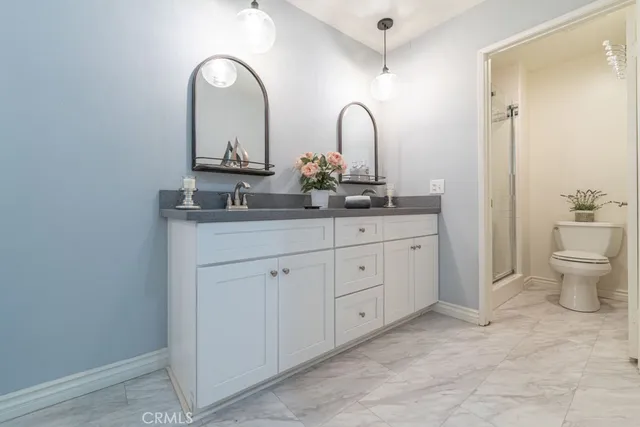a bathroom with a double vanity sink and a toilet