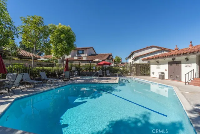a view of a white house with a big yard and potted plants