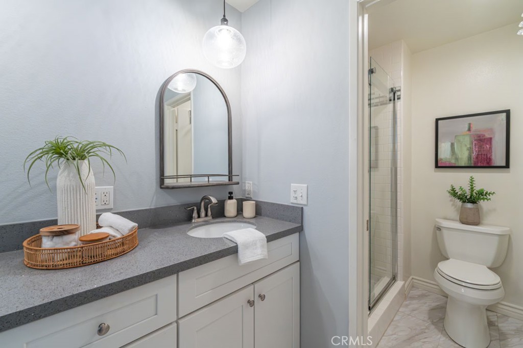 5002 East Atherton Street Long Beach, CA 90815 - Photo 37 of 52 a bathroom with a toilet a sink and a mirror