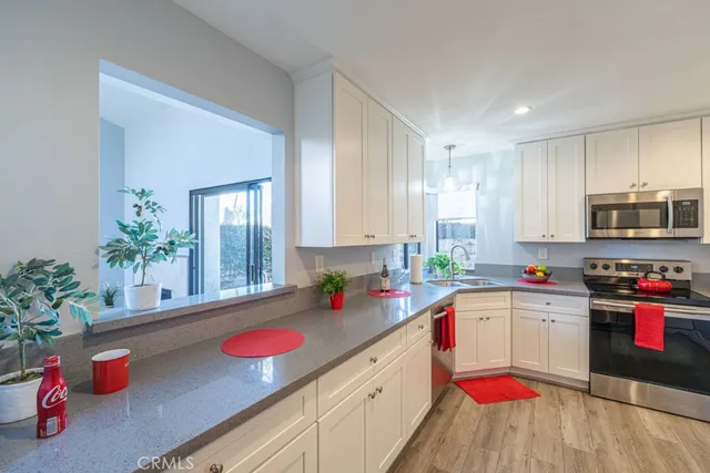 a kitchen with stainless steel appliances granite countertop a sink dishwasher and cabinets with wooden floor