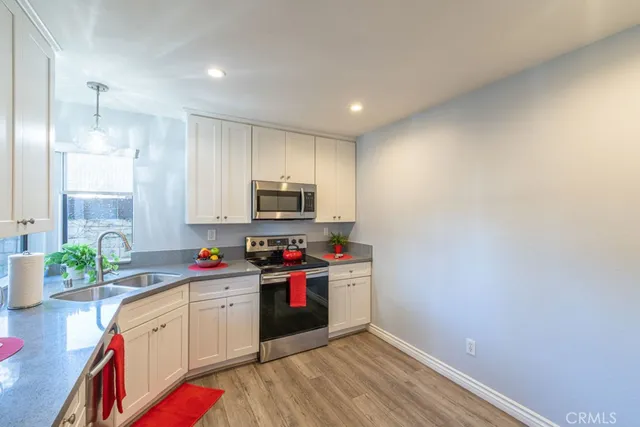 a kitchen with stainless steel appliances a sink stove and refrigerator