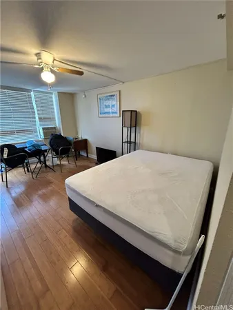 a large bed sitting in a room next to a lamp with window