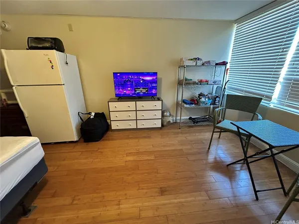 a living room with furniture and a refrigerator